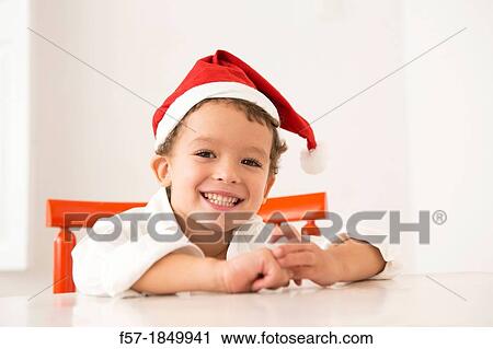 Four year old boy wearing a santa hat at Christmas View Large Photo Image Stock Image - Four year old boy wearing a santa hat at Christmas. Fotosearch