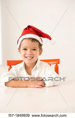 Four year old boy wearing a santa hat at Christmas View Large Photo Image Stock Photo - Four year old boy wearing a santa hat at Christmas. Fotosearch