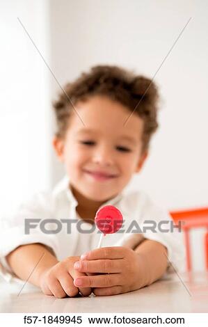 Stock Photography - Four year old boy with a red lollipop. Fotosearch