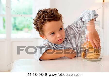 Four year old boy with his hand in the cookie jar View Large Photo Image Stock Photo - Four year old boy with his hand in the cookie jar. Fotosearch
