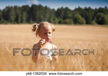 Four Year Old Girl Blowing Bubbles in Cornfield, Estonia View Large Photo Image Picture - Four Year Old Girl Blowing Bubbles in Cornfield, Estonia. Fotosearch