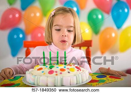 Stock Image - Four year old girl celebrating her birthday. Fotosearch