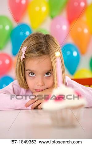 Stock Image - Four year old girl celebrating her birthday. Fotosearch