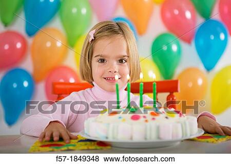 Stock Photo - Four year old girl celebrating her birthday. Fotosearch
