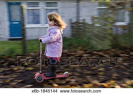 Four year old girl having fun riding a scooter View Large Photo Image Picture - Four year old girl having fun riding a scooter. Fotosearch
