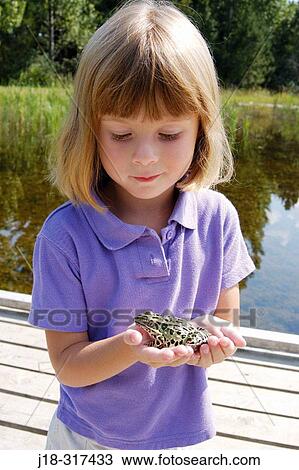 Stock Image - Four year old girl holding frog. Fotosearch
