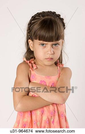 Picture - Four year old girl looking angryly at the camera in a studio setting. Fotosearch