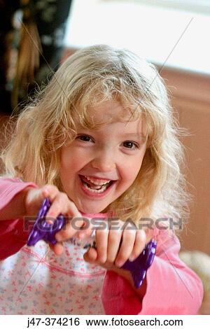 Four year old girl looking into camera, holding a toy View Large Photo Image Stock Photograph - Four year old girl looking into camera, holding a toy. Fotosearch