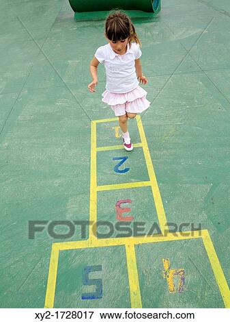Four year old girl playing hopscotch in a children's playground View Large Photo Image Stock Photo - Four year old girl playing hopscotch in a children's playground. Fotosearch