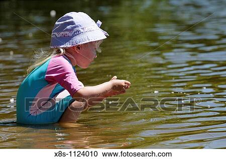 Four year old girl playing in the waters of a lake View Large Photo Image Stock Image - Four year old girl playing in the waters of a lake. Fotosearch