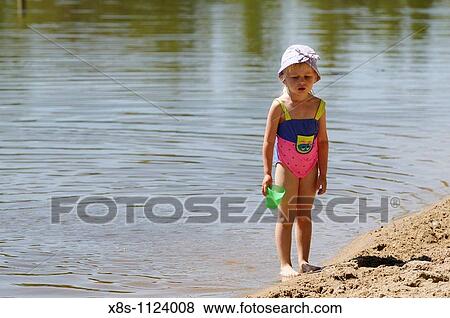 Four year old girl playing in the waters of a lake View Large Photo Image Stock Photo - Four year old girl playing in the waters of a lake. Fotosearch