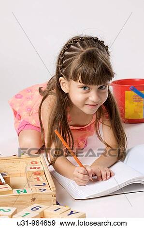Four year old girl smiling at the camera ready to do homework View Large Photo Image Stock Photo - Four year old girl smiling at the camera ready to do homework. Fotosearch