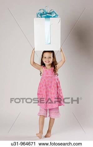 Four year old girl with a big present in a studio setting View Large Photo Image Stock Image - Four year old girl with a big present in a studio setting. Fotosearch
