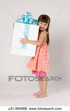 Four year old girl with a big present in a studio setting View Large Photo Image Stock Photo - Four year old girl with a big present in a studio setting. Fotosearch
