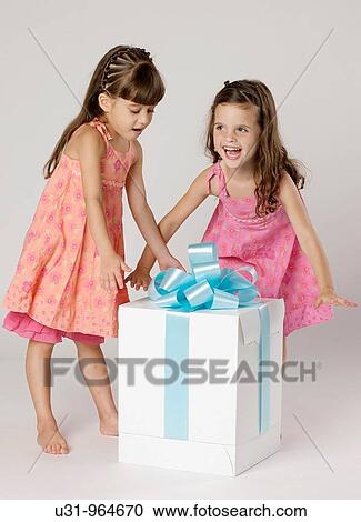 Four year old twins with a big present in a studio setting View Large Photo Image Stock Image - Four year old twins with a big present in a studio setting. Fotosearch