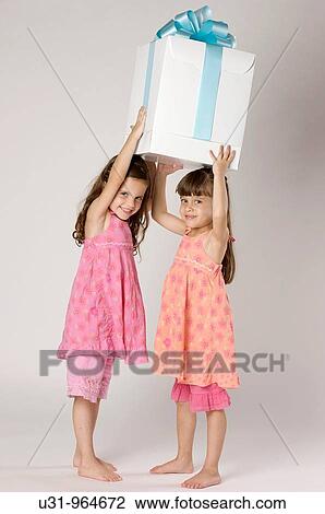Four year old twins with a big present in a studio setting View Large Photo Image Stock Image - Four year old twins with a big present in a studio setting. Fotosearch
