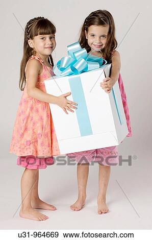 Four year old twins with a big present in a studio setting View Large Photo Image Stock Photo - Four year old twins with a big present in a studio setting. Fotosearch