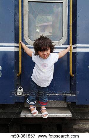 Stock Photo - Four years old Indian baby girl holding on to a train. India.. Fotosearch