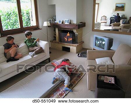 Four young children in living room watch TV by an open fire. Harmony. Peace. Quiet. Geneva. Switzerland. View Large Photo Image Stock Photo - Four young children in living room watch TV by an open fire. Harmony. Peace. Quiet. Geneva. Switzerland.. Fotosearch
