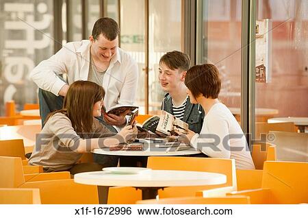 Four young teenagers in a reading group people friends enjoying reading books in a cafe UK View Large Photo Image Stock Photograph - Four young teenagers in a reading group people friends enjoying reading books in a cafe UK. Fotosearch