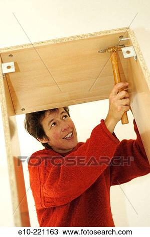 Fourty year old woman assembling cupboard with hammer View Large Photo Image Stock Image - Fourty year old woman assembling cupboard with hammer. Fotosearch