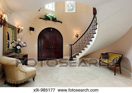 Stock Photo - Foyer in luxury home with curved staircase. Fotosearch
