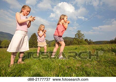 France, Bas Rhin, Urbeis near the Climont, girls in a meadow. View Large Photo Image Stock Photo - France, Bas Rhin, Urbeis near the Climont, girls in a meadow.. Fotosearch