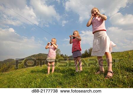 Stock Photo - France, Bas Rhin, Urbeis near the Climont, girls in a meadow.. Fotosearch