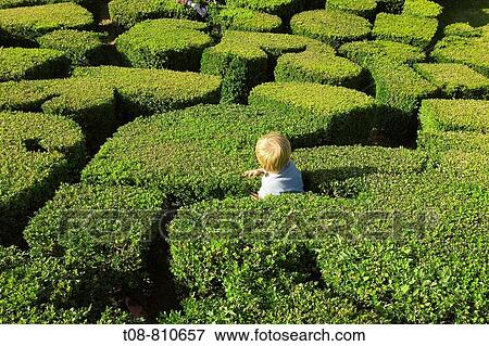 Stock Photo - France, Ile de France, park of Breteuil castle: child playing in the hedge. Fotosearch