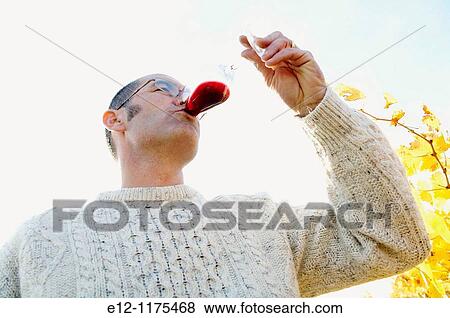 Stock Photo - France, Vaucluse, Cairanne, wine grower & producers, Domaine de l? Oratoire St Martin, Fran? ois Alary testing his wine in vineyards.. Fotosearch