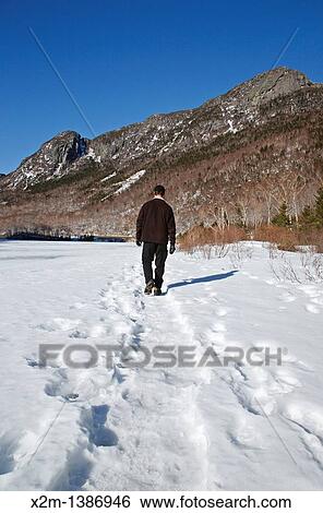 Franconia Notch State Park - Man walking on the edge of Profile Lake with Eagle Cliff in the background in the White Mountains, New Hampshire USA during the winter months View Large Photo Image Stock Photograph - Franconia Notch State Park - Man walking on the edge of Profile Lake with Eagle Cliff in the background in the White Mountains, New Hampshire USA during the winter months. Fotosearch