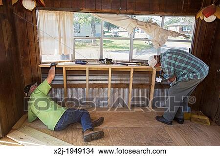 Picture - Franklin, Louisiana - Volunteers replace the rotted floor of an elderly resident's mobile home that was damaged by storms. The volunteers are working through the United Methodist Church's Sager Brown disaster relief depot.. Fotosearch