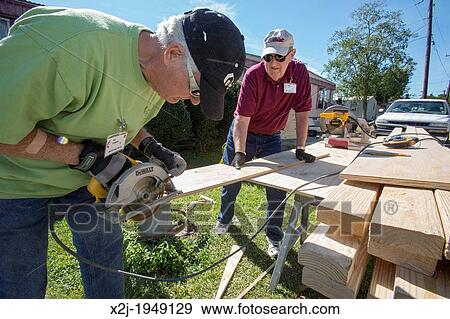 Stock Photo - Franklin, Louisiana - Volunteers replace the rotted floor of an elderly resident's mobile home that was damaged by storms. Ed Lobnitz (left) and Philip Keyes are working through the United Methodist Church's Sager Brown disaster relief depot.. Fotosearch