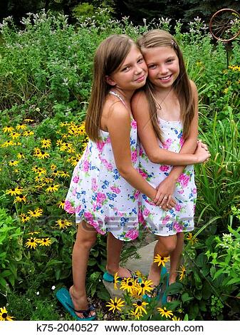 fraternal twin sisters hugging View Large Photo Image Stock Photo - fraternal twin sisters hugging. Fotosearch