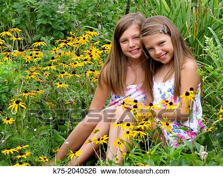 Fraternal twins in garden of flowers View Large Photo Image Stock Photograph - Fraternal twins in garden of flowers. Fotosearch