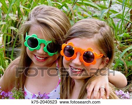 Stock Image - Fraternal twins with sunglasses. Fotosearch