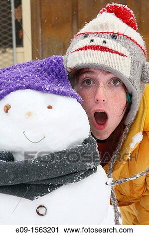 freckled girl in sock-monkey hat and yellow parka, standing with mouth open behind the snowman she built - snowman has purple hat, grey scarf View Large Photo Image Stock Image - freckled girl in sock-monkey hat and yellow parka, standing with mouth open behind the snowman she built - snowman has purple hat, grey scarf. Fotosearch