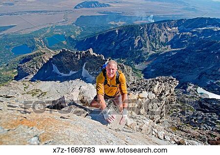 Stock Image - Free solo rock climbing The Direct South Ridge route which is rated grade 3 at 5, 7 on Nez Perce Peak in Grand Teton National Park in northern Wyoming. Fotosearch