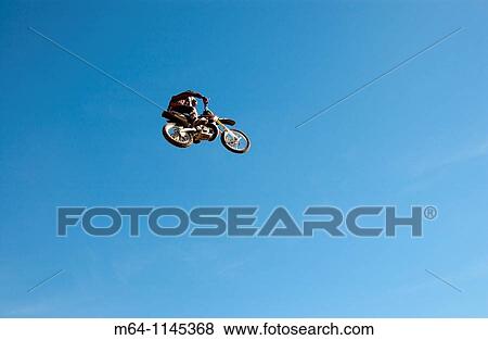 Freestlye motocross rider jumping from a ramp View Large Photo Image Stock Photo - Freestlye motocross rider jumping from a ramp. Fotosearch