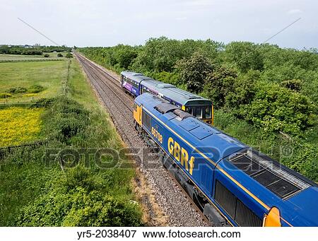 Stock Photo - Freight train passing passenger train on the north east coast of England, United Kingdom.. Fotosearch