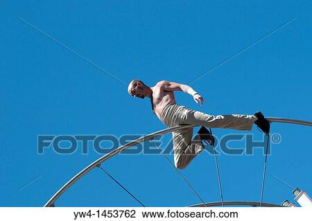 Stock Image - French acrobat performs for Festival of San Isidro, Plaza de la Corrala in Lavapies, Madrid, Spain. Fotosearch