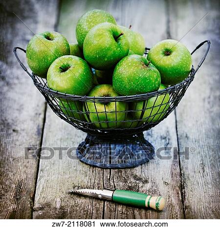 Fresh green apples variety Granny Smith in a wire basket on a weathered wooden table. View Large Photo Image Stock Image - Fresh green apples variety Granny Smith in a wire basket on a weathered wooden table.. Fotosearch