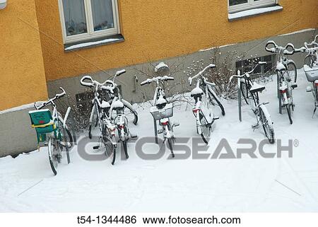 Fresh snow lies on parked bicycles View Large Photo Image Stock Photograph - Fresh snow lies on parked bicycles. Fotosearch