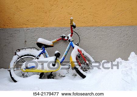 Stock Photo - Fresh snow on a colorful children bicycle. Fotosearch