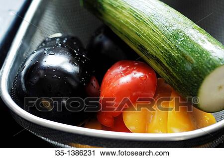 Stock Image - Freshly washed pepper, eggplant and zucchini in a basket. Fotosearch