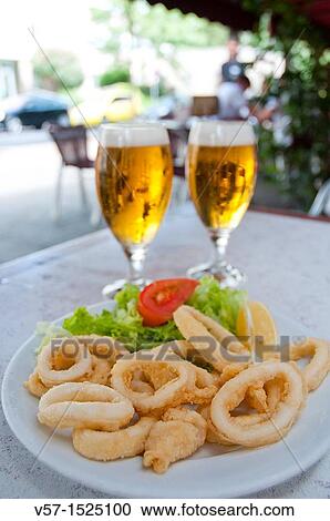 Stock Image - Fried squids serving and two glasses of beer in a terrace. Madrid, Spain.. Fotosearch