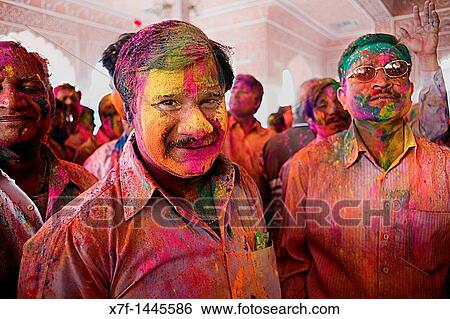 Stock Photograph - Friends celebrating the Holi spring festival to celebrate the love between Krishna and Radha, in Govind Devji temple, Jaipur, Rajasthan, India. Fotosearch