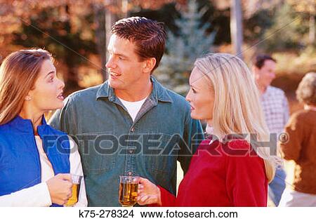 Friends chatting outdoors View Large Photo Image Picture - Friends chatting outdoors. Fotosearch