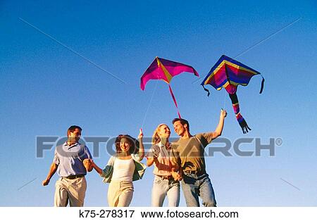 Friends flying a kite View Large Photo Image Stock Photo - Friends flying a kite. Fotosearch