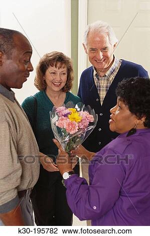 Stock Image - Friends greeting at door. Fotosearch